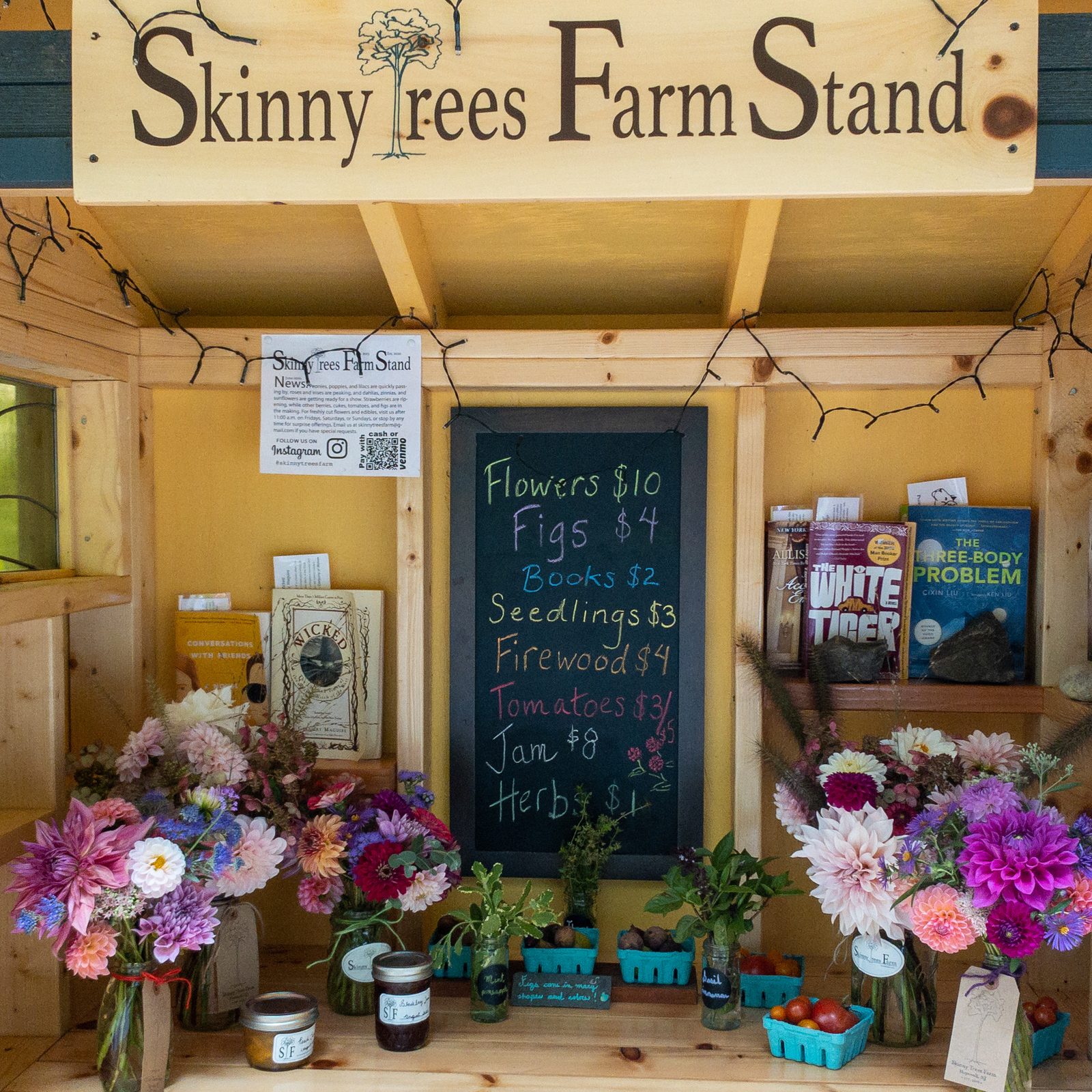 The Skinny Trees Farm stand: bouquets in mason jars, a chalkboard of prices, figs, jam, and used books.